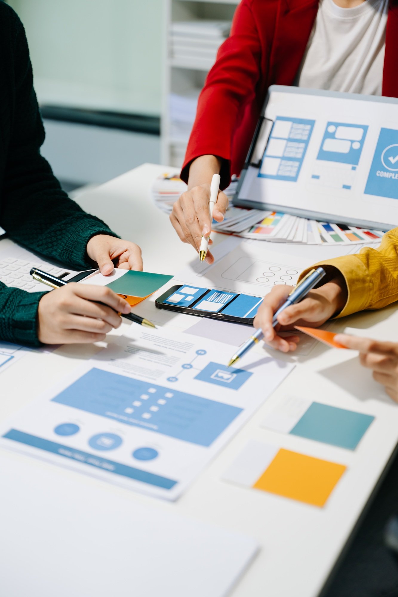 Close up view of UI developer team brainstorming on their project with laptop, smartphone